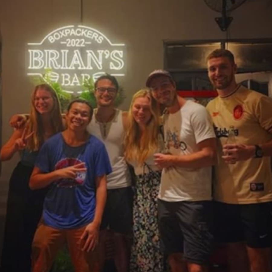 Guests under the neon Brian's Bar sign